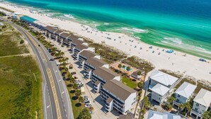 Vista aérea de un hotel costero con varias construcciones, una playa y una carretera.