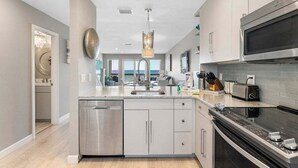 Una cocina moderna con electrodomésticos de acero inoxidable, lavavajillas y microondas.