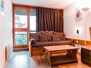 A cozy room with a wooden sofa, a wooden table, and a view of the outside. - 7th floor, balcony, tv, 40m², Les Arcs (Les Arcs)
