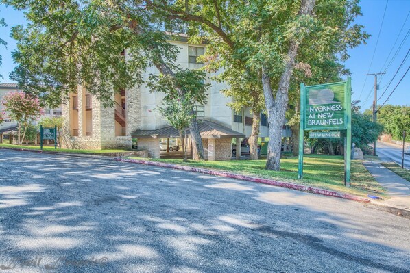 Un edificio con un letrero que dice "Inverness at New Braunfels" y una señal de calle que indica "401 W. Lincoln".