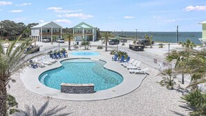 A resort with a large pool, lounge chairs, and a view of the ocean. - Sunshine And Flip Flops Sp114 4 Bedroom Home by RedAwning (Fulton)