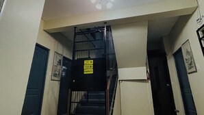 A staircase with a sign indicating no smoking and a closed door. - 83 F. Bautista St (Quezon City)