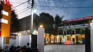 A wedding hall with a sign, a motorcycle parking area, and a well-lit entrance. - WM Hotel Arugambay (Arugam Bay)
