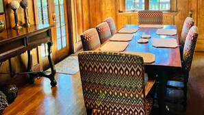 A dining room with a wooden interior, a large table, patterned chairs, and a chandelier. - Wildwood a great family house Sleeps up to 10!  Walk to trails! (Inverness)