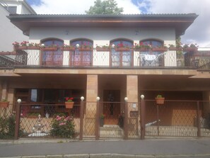 A two-story building with a balcony, potted plants, and a gated entrance. - Villa Barrandov  (Hlavní mesto Praha)
