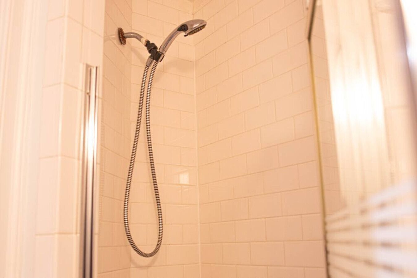 A shower with a handheld showerhead and a flexible hose.