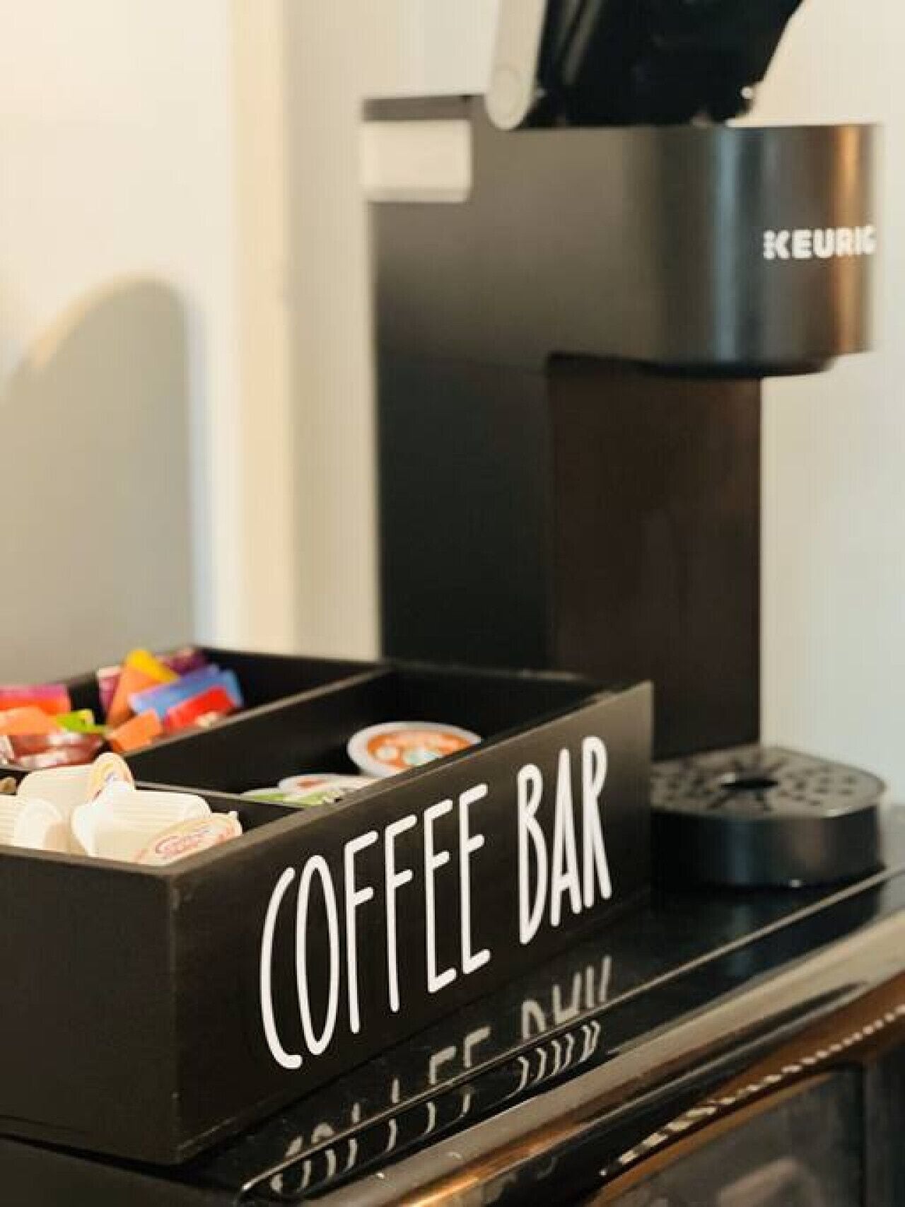 A coffee machine with a coffee bar below it.