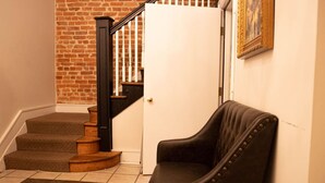 A staircase with wooden steps and a black handrail, leading to a white door.