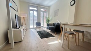 Un salon moderne avec un canapé, une table à manger et un téléviseur.
