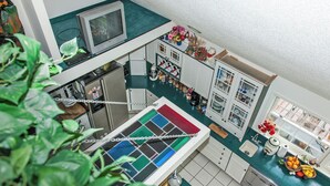 Une cuisine avec un mur recouvert de carreaux, un réfrigérateur, un évier et une fenêtre donnant sur l’extérieur.