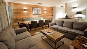Un salon moderne comprenant un canapé, une table basse et un coin repas avec des chaises et une table.