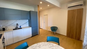 A modern kitchen with white cabinets, a marble countertop, and a blue chair. - CaseMaggi Poets Bay Terrace with stunning views, perfect for families & friends (Portovenere)