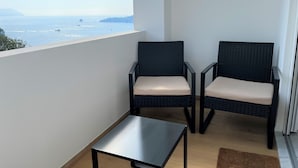 A balcony with two chairs and a small table, overlooking a coastal view. - CaseMaggi Poets Bay Terrace with stunning views, perfect for families & friends (Portovenere)