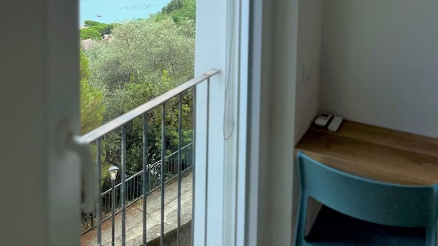 A balcony with a view of the sea, a wooden table, and a metal railing. - CaseMaggi Poets Bay Terrace with stunning views, perfect for families & friends (Portovenere)