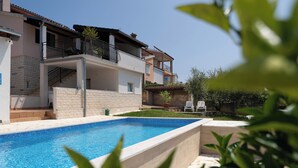 A modern residential building with a swimming pool, balconies, and a well-maintained garden. - Villa Sunset with spectacular views (Porec)