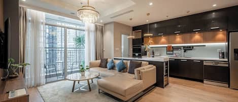 Una sala de estar moderna con sofá, mesa de centro y vistas de la ciudad a través de amplias ventanas.