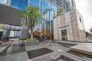 A modern building with a Starbucks on the ground floor, a large glass facade, and a water feature in the plaza. - Landmark 81 & Vinhomes - ZEN Saigon Citypoint. (Ho Chi Minh City)