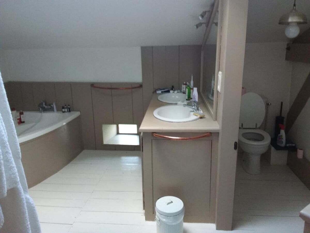 A bathroom with a sink, mirror, toilet, and bathtub.