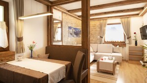 Een gezellige kamer met een bed, een bank, een klein tafeltje en een televisie.