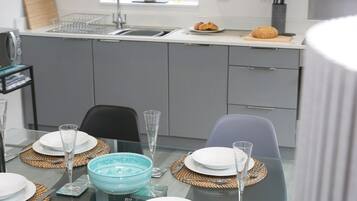 A modern kitchen with grey cabinets, a stainless steel sink, and a window above the sink.