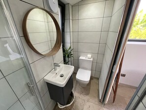 A compact bathroom with a sink, toilet, and a mirror. - River View Guest House, Jacuzzi, Boat, Fire Hire (Staines)