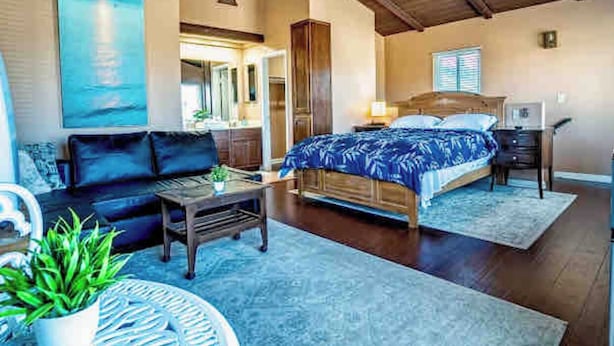 A bedroom with a large bed, a nightstand, a dresser, and a window. - Studio Suite with Private, Secured Entrance, No Shared Spaces, Driveway Parking  (Spring Valley)
