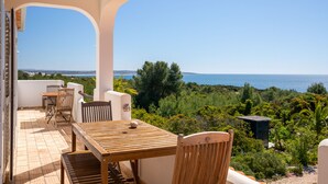 A terrace with a table and chairs, a view of the sea, and surrounding greenery. - Casa Galo Verde, 4 persons, super sea view (Porches)