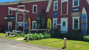 Un bâtiment rouge avec de nombreuses fenêtres et une enseigne indiquant un service de location de canoës et de kayaks.