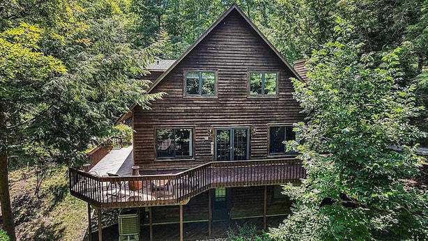 A wooden cabin with a balcony, surrounded by dense forest. - Peaceful, Woodland Retreat in Frankfort, MI Near Crystal Lake & Sleeping Bear (Frankfort)