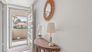 Un passadís amb una consola de fusta, una làmpada i un mirall decoratiu.