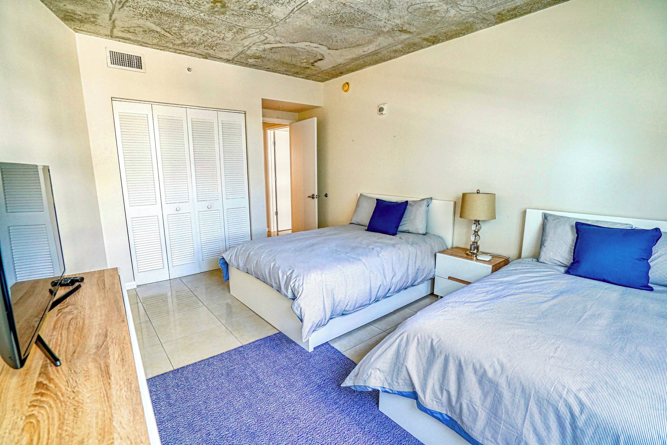 Une chambre avec deux lits, un bureau et une armoire.