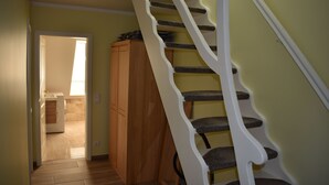 Una escalera de diseño único, un armario de madera y una puerta que da a otra habitación.