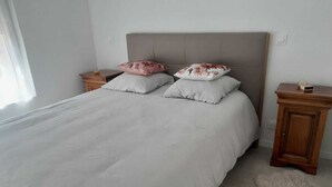 A bedroom with a large bed, two nightstands, a wooden cabinet, and a fluffy rug. - 24h House (Le Mans)