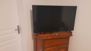 A wooden TV stand with a flat-screen TV. - 24h House (Le Mans)