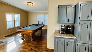 A spacious room with a pool table, built-in cabinets, and a ceiling light fixture. - Jack The Horse Lake Cabin -Pool Table-Wifi-Tub-Trails-Peaceful-Dining Closeby! (Marcell)