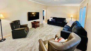 A living room with a flat-screen TV, two couches, a coffee table, and a lamp. - Jack The Horse Lake Cabin -Pool Table-Wifi-Tub-Trails-Peaceful-Dining Closeby! (Marcell)