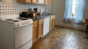 A kitchen with wooden cabinets, a white stove, and a black countertop.