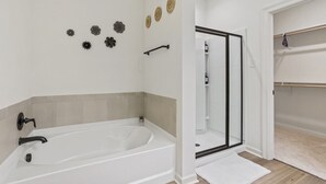 Un baño moderno con bañera, ducha y zona de ducha a ras de suelo.