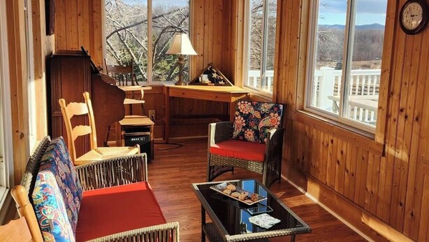 Une pièce aux murs lambrés, avec un canapé, des fauteuils et une table.