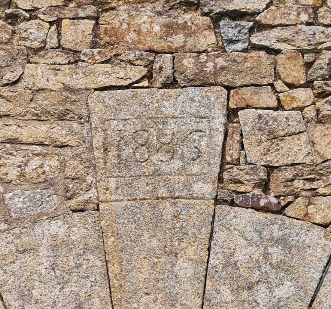 A stone wall with a carved inscription.