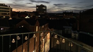 Ein Stadtbild in der Dämmerung mit Gebäuden und einem klaren Himmel.