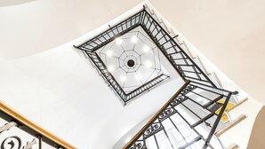 A high-ceilinged atrium with a geometric skylight and a spiral staircase. - Villa Michelangelo, your home in the heart of the eternal city (Roma)