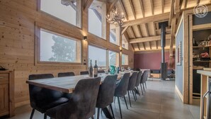 A spacious dining area with a long wooden table, multiple chairs, and a chandelier. - MONT ROSE - LA PLAGNE TARENTAISE (LA PLAGNE TARENTAISE)