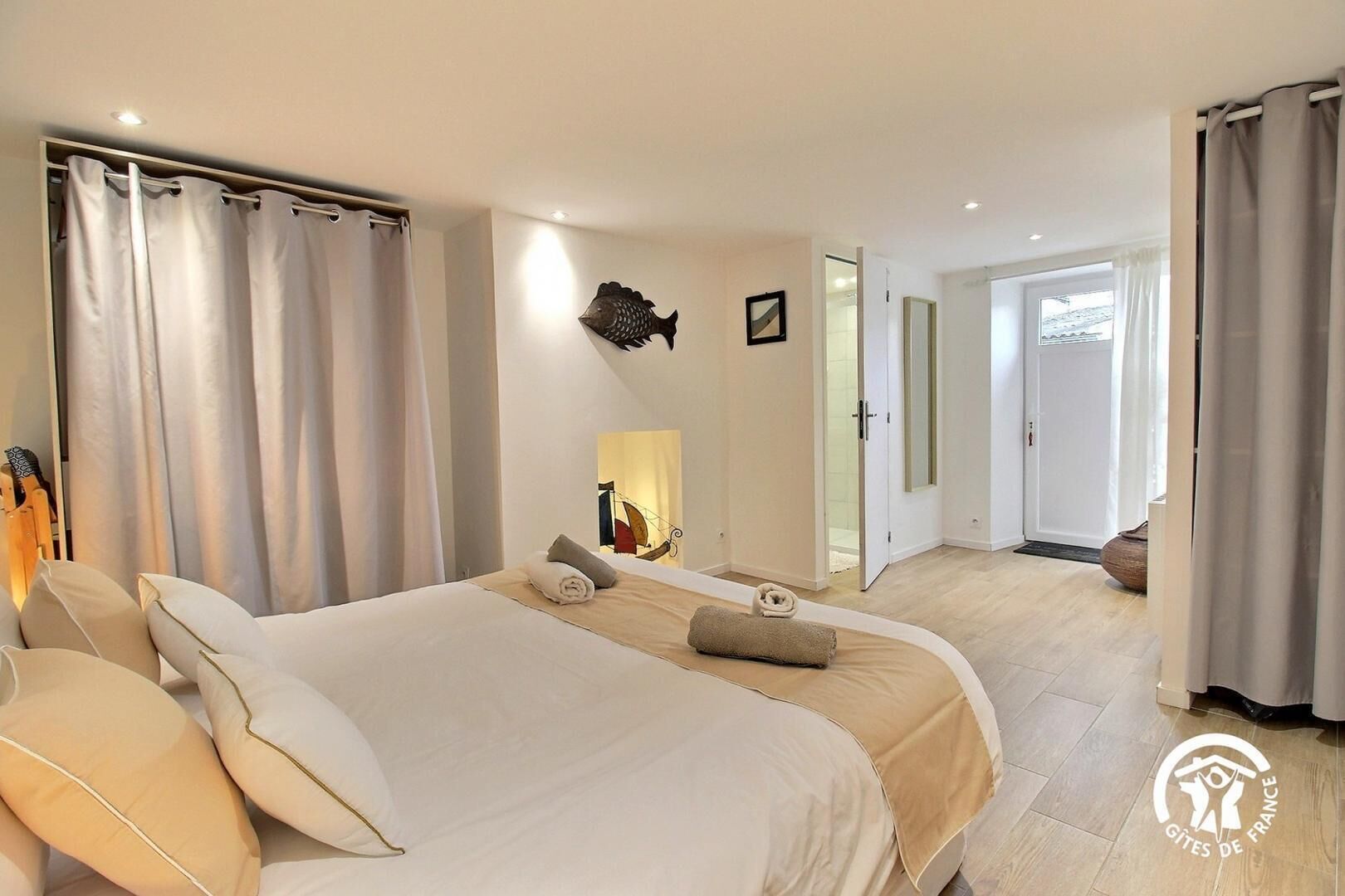 A hotel room with two beds, a large mirror, and a view of the outside.