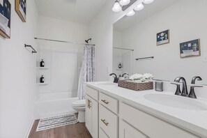 Ein modernes Badezimmer mit einem Doppelwaschtisch, einer Duschkabine und einer Toilette.