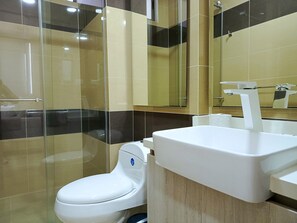 A modern bathroom with a toilet, a sink, and a glass shower enclosure. - Exclusive Apartment in Beach Club (Gaira)