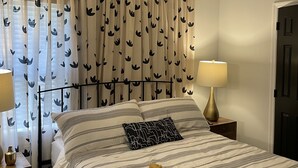 A bedroom with a bed, two bedside tables with lamps, a ceiling fan, and a window with patterned curtains. - 2 Bed/2 Bath Home in Andover area. Premier Host with 250+ 5-Star Reviews! (Lexington)