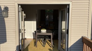 A patio area with a table and chairs, a door leading to an interior space, and a wooden deck. - 2 Bed/2 Bath Home in Andover area. Premier Host with 250+ 5-Star Reviews! (Lexington)