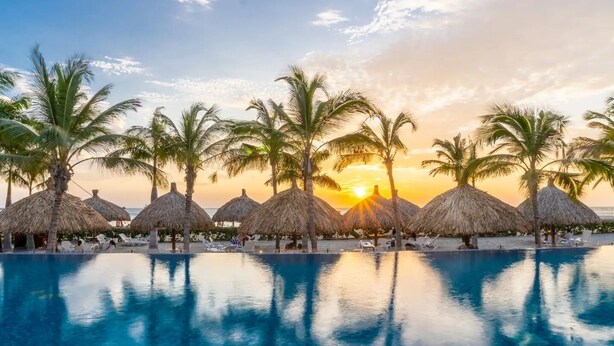 A poolside area with thatched umbrellas, palm trees, and lounge chairs. - Luxurious Sea View Apartment - Samaria Club (Gaira)