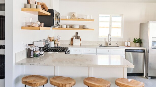 A modern kitchen with white cabinetry, wooden stools, and stainless steel appliances. - Private Guest House with Full Kitchen, 30 minutes to L.A. & Beach (Thousand Oaks)